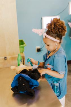 A child examining pet toys like a vet
