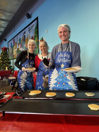 Volunteers serving pancakes at Hands on Holidays